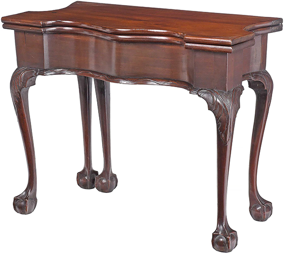 New York mahogany five-legged card table, 18th century, its deeply shaped top opening to a baize-lined playing surface with chip recesses, the conforming frieze with vine-carved molding, on cabriole legs with ball-and-claw feet, 27½