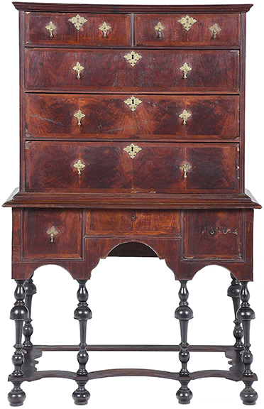 New England William and Mary figured walnut high chest, probably Boston, circa 1710, with highly figured veneers, engraved brasses, the original ebonized legs and feet with shaped stretchers, and white pine secondary wood, 61½