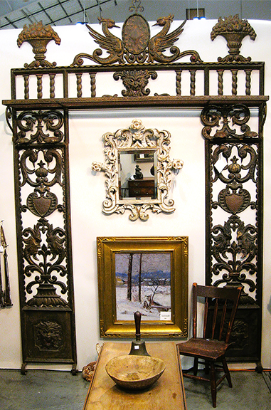 Art Pappas Antiques, Woodbury, Connecticut, erected a magnificent cast-metal architectural element with phoenixes and masks, late 19th or early 20th century. This could make a great interior, but it would have to be in the right place. The dealer had found it in Florida—which makes sense—but was still thinking about the price. The carved wooden frame at center with a beveled glass mirror was $1150.