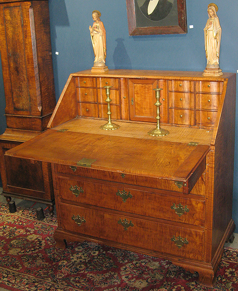 Steve Jenkins of Lorida, Florida, from the family that manages the show, had two tiger maple desks; the one shown was $3800. The 1723 tall-case clock, partially seen at left, was $6500.