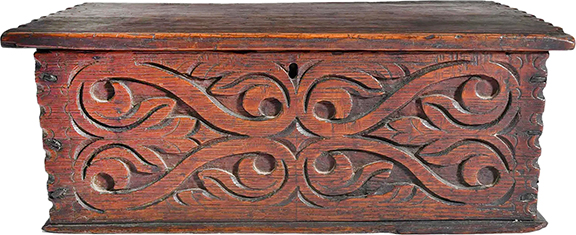The interior of this diminutive carved oak box from 1670-1700 is decorated with sections of colorful wallpaper. The 5