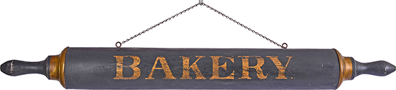 A wooden trade sign in the form of a full-dimensional oversized baker’s rolling pin, 48