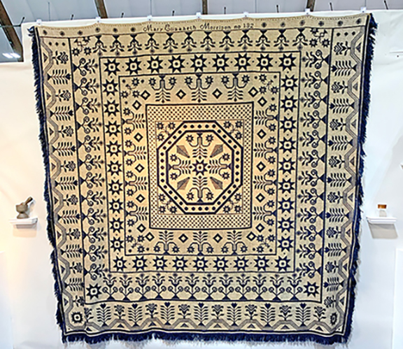 The first booth off the entrance belonged to Brendan Edgerton of Portsmouth, New Hampshire, who trades as Country Cupboard Antiques. During early buying, shoppers were eager and sales were already in progress. Front and center was the spectacular coverlet, numbered 132, worked and signed by Mary Elizabeth Morrison, a known New Hampshire artisan. The coverlet was priced at $22,000, and when we passed by the booth later, it had a red tag&mdash;sold to a New Hampshire collector.