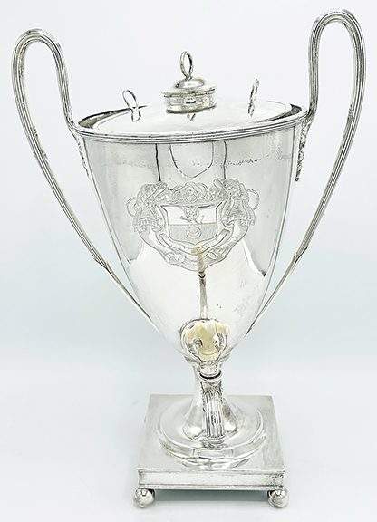 The George III sterling silver tea urn by Hester Bateman (English, 1708-1794), London, 1789, with reeded loop handles and on a square base, 18¼