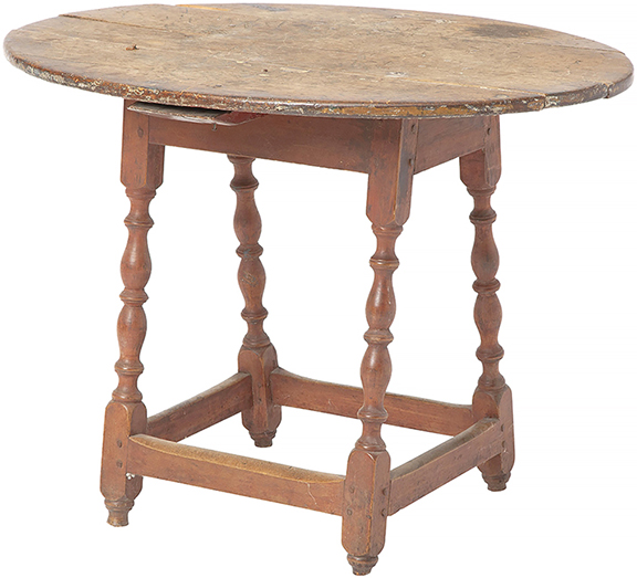 Red-painted pine and maple oval tap table, New England, 18th century, the cleated overhanging top on a canted apron joining turned legs, 23¾