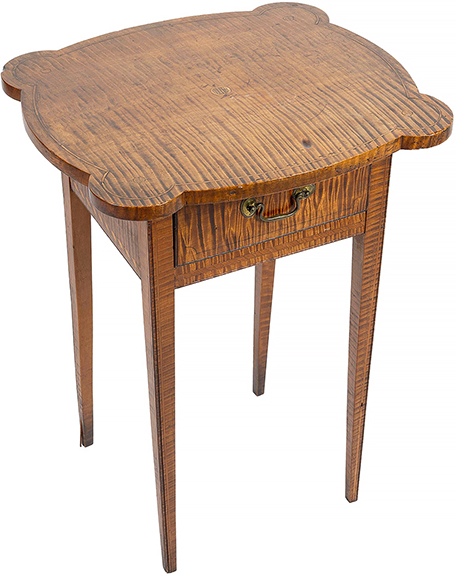 An unusual highly figured maple table, New England, circa 1800, with shaped overhanging top with line inlay along the perimeter and coin inlay at the center and at each of the out-rounded corners. The single drawer is painted to simulate cut-corner line inlay. Measuring 27