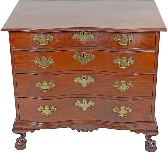 This circa 1770 Boston mahogany oxbow chest is attributed to John Cogswell and sold for $37,800 (est. $30,000/50,000). It has a one-board overhanging top with molded edge, four graduated full-width drawers with cock-bead molding, brasses and escutcheons believed to be original; a molded base with a fan-carved pendant drop, and ball-and-claw feet. The 32¾