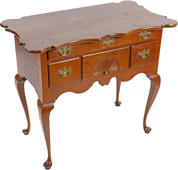 This Connecticut Queen Anne cherry dressing table with a scalloped top from the Wethersfield area is rare and important. It was made around 1750 with out-rounded corners, scalloped on three sides, with a full width drawer over three smaller drawers, the central one with a carved fan, and a scrolled apron. It exhibits traits associated with the Wethersfield school: the fluidity of the skirt, the carved fan style, canted knee brackets, and truncated pads on the feet. It was estimated at $25,000/50,000 and realized $189,000. The table was discovered in Clinton, Connecticut, in 1945 by Betty H. Richmond and her husband; a letter from Mrs. Richmond on the letterhead of William’s Antique Shop in Old Greenwich, described how she and her husband discovered the piece. It sold at Christie’s Americana sale, January 23, 1988, to John Walton, Inc. for $82,500; then to the collection of Thomas and Alice Kugelman of Hartford; to Marguerite Riordan, of Stonington, 1999; to the collection of Nancy and Larry Dickson. The table was published in Connecticut Furniture: Seventeenth and Eighteenth Centuries by Henry P. Maynard (1967).