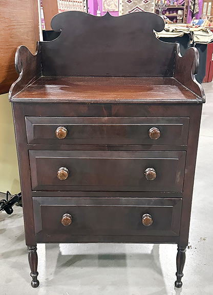 Joyce and Roy Williams of Hoot and Nana Antiques, Paris, Kentucky, offered this diminutive three-drawer chest (possibly a child’s server) with a scrolled gallery, in mahogany with its original finish, on turned legs with ball feet. Dating to the 1820s and thought to be a salesman’s sample, the chest measures 33½