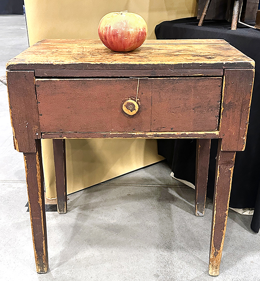 This early, one-of-a-kind desk/table with a crusty red surface, having a single drawer and worn natural top, 28½