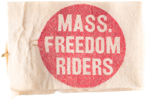 This 1961 felt armband, bound with a safety pin closure, reads “Mass. Freedom Riders” in a red circle. It is an artifact of the Congress of Racial Equality (CORE), which sponsored freedom rides that sought to integrate mass transit in the segregated South. It is 5½