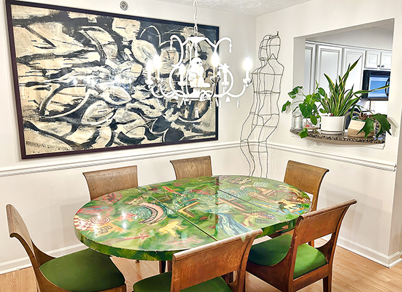 On the left wall in the dining room are a photograph by Michael Penn; part of a crate from the Chelsea Flea; and a print by Sebastian Errazuriz, a Chilean-born artist, bought from his Instagram. The monkey chandelier came from Big Apple Antiques. The dining table is from restaurant/nightclub Wet Paint Cafe, which was located on Lincoln Road in Miami. Vieira bought the table on Instagram from dealer Doubles Tennis. The large black-and-white painting, unsigned, was found in Queens and brought home “Heather style”—on the ferry. The life-size wire-form sculpture came from a shop in Georgia.