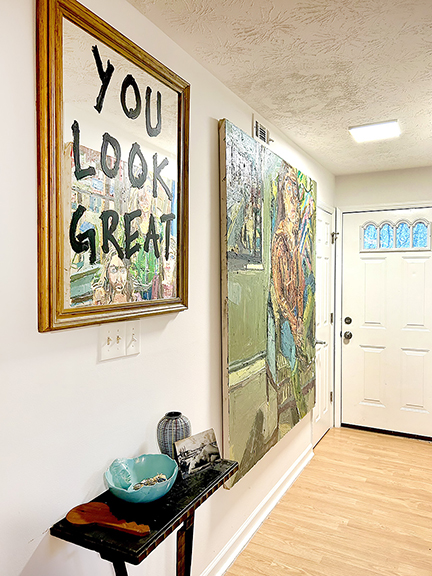 In the entryway is a mirror with the words “You Look Great,” which Vieira painted. A portrait of Vieira by Clintel Steed (b. 1977) hangs next to the mirror, and in its reflection one can see a Steed portrait of Vieira and her two daughters, painted circa 2018.