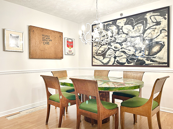 On the left wall in the dining room are a photograph by Michael Penn; part of a crate from the Chelsea Flea; and a print by Sebastian Errazuriz, a Chilean-born artist, bought from his Instagram. The monkey chandelier came from Big Apple Antiques. The dining table is from restaurant/nightclub Wet Paint Cafe, which was located on Lincoln Road in Miami. Vieira bought the table on Instagram from dealer Doubles Tennis. The large black-and-white painting, unsigned, was found in Queens and brought home “Heather style”—on the ferry. The life-size wire-form sculpture came from a shop in Georgia.