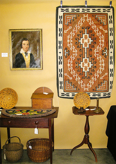 Warm tones in the booth of R. Stephen Johns of Grosbeak Antiques, Bloomington, Indiana, included a Navajo rug, Two Grey Hills design, 1920-40, for $975, along with many baskets. The circular basket immediately below the rug was $1450.