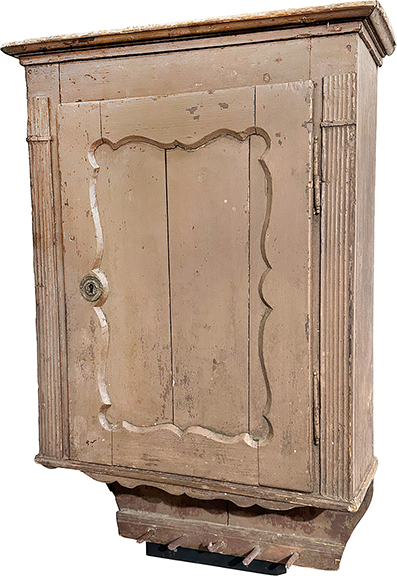 In brown paint and dating to the 18th century, this hanging cupboard has a lower set of clothes pegs and a shelved interior with two lower drawers. It is dovetailed and has rosehead nails. Measuring 40