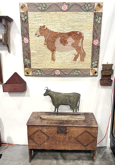  Cattle dominated one corner of the booth of Bettina Krainin of Bethlehem, Connecticut. The folky hooked rug with a central bovine and bee skeps in the corners, mounted, 36½