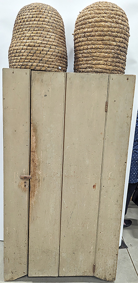 The early straw bee skeps were $750 apiece while the one-door kitchen cupboard in an older putty-gray paint was $1050 from Matt Ehresman Antiques, Wadsworth, Ohio.