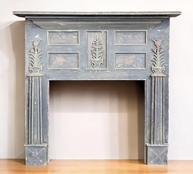 This recently discovered early 19th-century Federal style yellow pine mantel is attributed to an unknown maker in Shenandoah County (now Page County), Virginia. Below the shelf is a tapering cornice-like step-molded detail. Above the firebox opening is a wide header with five framed panels, four with painted decoration, and the fifth with an applied floral stem cutout. The legs are slightly tapered and topped with applied cutout tulip and urn elements. The mantel displays an overall worn blue-gray surface with polychrome accents to the cutouts and panels. Overall measurements are 55½