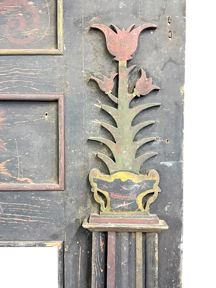 This recently discovered early 19th-century Federal style yellow pine mantel is attributed to an unknown maker in Shenandoah County (now Page County), Virginia. Below the shelf is a tapering cornice-like step-molded detail. Above the firebox opening is a wide header with five framed panels, four with painted decoration, and the fifth with an applied floral stem cutout. The legs are slightly tapered and topped with applied cutout tulip and urn elements. The mantel displays an overall worn blue-gray surface with polychrome accents to the cutouts and panels. Overall measurements are 55½
