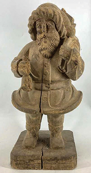 The finely detailed folk-art Santa Claus figure is carved from a single block of wood and retains an undisturbed dry surface. Santa stands 23