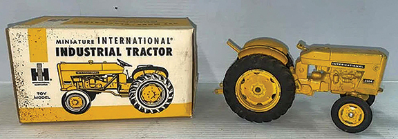 The miniature International Harvester tractor Model 2504 with its original box sold for $480.25. The 1/16 scale die-cast model from the mid-1960s retains its original paint. The steering wheel is missing.