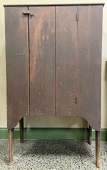 This primitive jelly cupboard was one of the sale’s most actively contested lots. The cupboard features simple nailed construction with tall rounded bootjack ends. The board-and-batten door opens to reveal five fixed shelves. The 54½