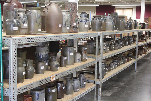 Previewing sales at Laughlin Auctions has been eased by the firm’s orderly transition from live to online events. Rows of shelving have replaced chairs in the warehouse-size galleries. Here stoneware lots are lined up in order of sale for the annual spring auction. Newman photo.
