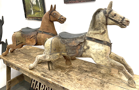 Two figures from a flying-horse carousel having 16 horses and two chariots, being sold as a complete unit for $26,000 by Seth Bixel of Bluffton, Ohio. The amusement ride was made by the United States Merry-Go-Round Company of Cincinnati, Ohio. The photograph shows the carousel, which was fully operational when last disassembled.