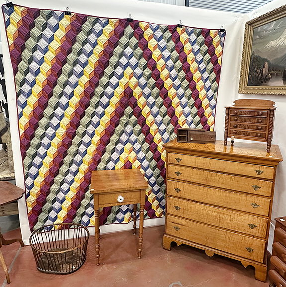Tumbling Blocks quilt, $575; unidentified basket or strainer, $55; tiger maple single-drawer stand on turned legs, 30½