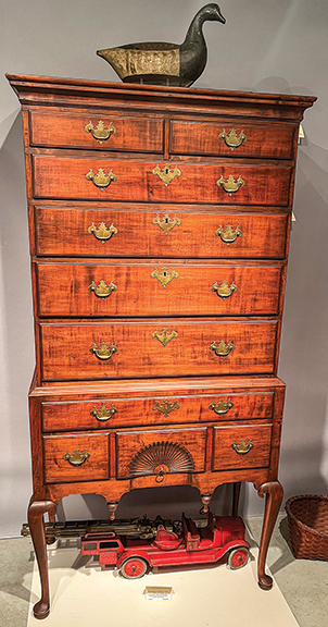 Circa 1770 flat-top highboy with a carved fan and long cabriole legs ending in pad feet, all original, including the brasses, $16,000 from J & G Antiques, Amityville, New York. The root-head brant by David Henry Cochran of Blue Point, New York, is in its original paint and was part of W.L. Suydan’s hunting rig.