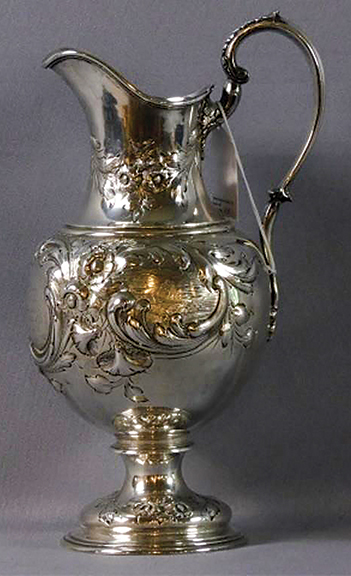 This coin silver presentation pitcher by Mulford & Wendell of Albany, New York, was presented to William C. Young, superintendent of the Utica-Schenectady Railroad, by his friends September 15, 1849. The occasion was his resignation from the Utica-Schenectady Railroad to become chief engineer and later president of the Hudson River Railroad. The pitcher is engraved with an image of a railroad bridge, two trains, and a railroad engineer or surveyor, believed to be Young (1799-1893). It had descended in the family and sold for $6300 (est. $3000/5000).