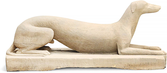 Carved stone dog, southern Ohio, mid-19th century, the life-size figure made of sandstone and representing a greyhound or whippet, resting on an integral plinth, 46