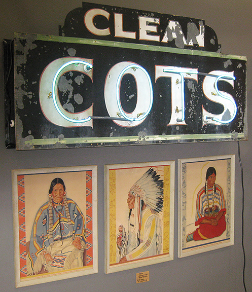 Klint Griffin of PROPS, Leiper’s Fork, Tennessee, hung on the wall a 1940s sign, “CLEAN / COTS,” with restored neon, priced at $3600. Below are three 1950s prints of Blackfeet Indians from Glacier National Park by artist Winold Reiss (1886-1953).