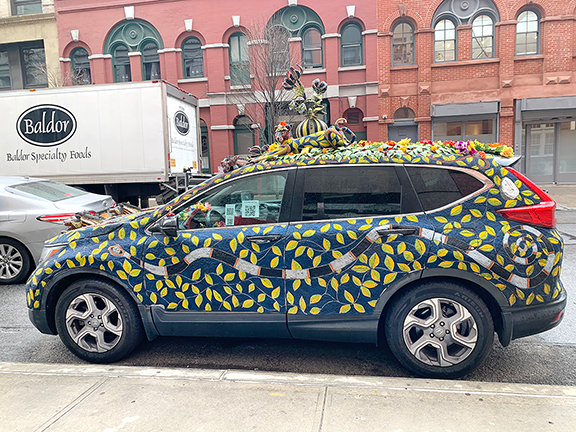 A side view of the beaded car, with a QR (quick response) code affixed to the driver’s side window to download information on the fair.