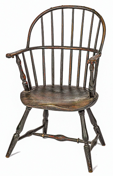 Pennsylvania sack-back Windsor chair, circa 1790, with knuckle armrests, retaining an old green surface, sold for $1386 (est. $400/800).