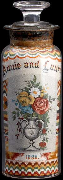 The top lot of the sale was this sand bottle by Andrew Clemens (1857-1894) of McGregor, Iowa. It is decorated in grains of Saint Peter sandstone, with one side inscribed “Annie and Laura” and “1888” below an urn of colorful flowers and the other side with an American ship under full sail above a panel marbled to resemble the Saint Peter sandstone deposits at Pictured Rocks, Pikes Peak, Iowa. Estimated at $6000/8000, the 6¾