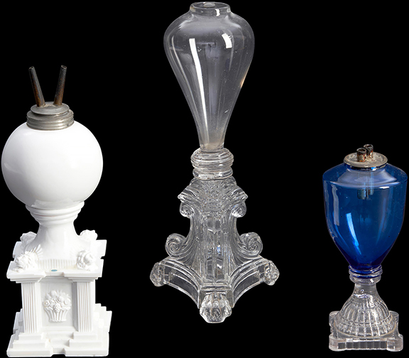A lot with three mid-19th-century blown and pressed glass lamps, estimated at $200/400, brought $5888. From left to right: an opaque white blown glass font joined to a press-molded lion and basket of flowers pedestal, made in Massachusetts, circa 1840, overall height 7½