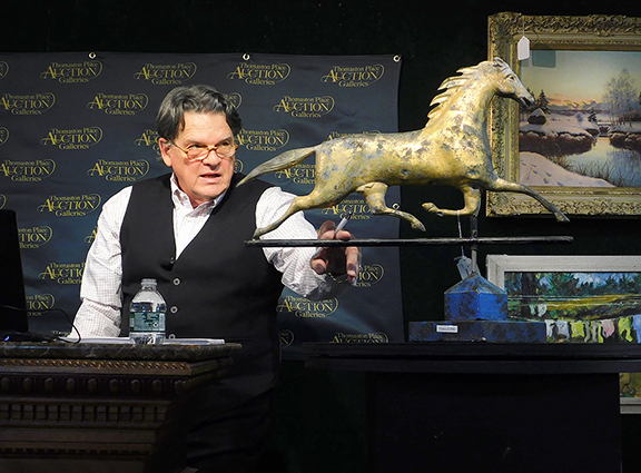 Auctioneer Kaja Veilleux hammers down a 19th-century full-body copper running horse weathervane with a cast-zinc head. With a repaired tail, gilding loss, and body dents, including possible bullet holes, it still won by a nose at $1250, with a $1000/2000 estimate. Sisco photo.